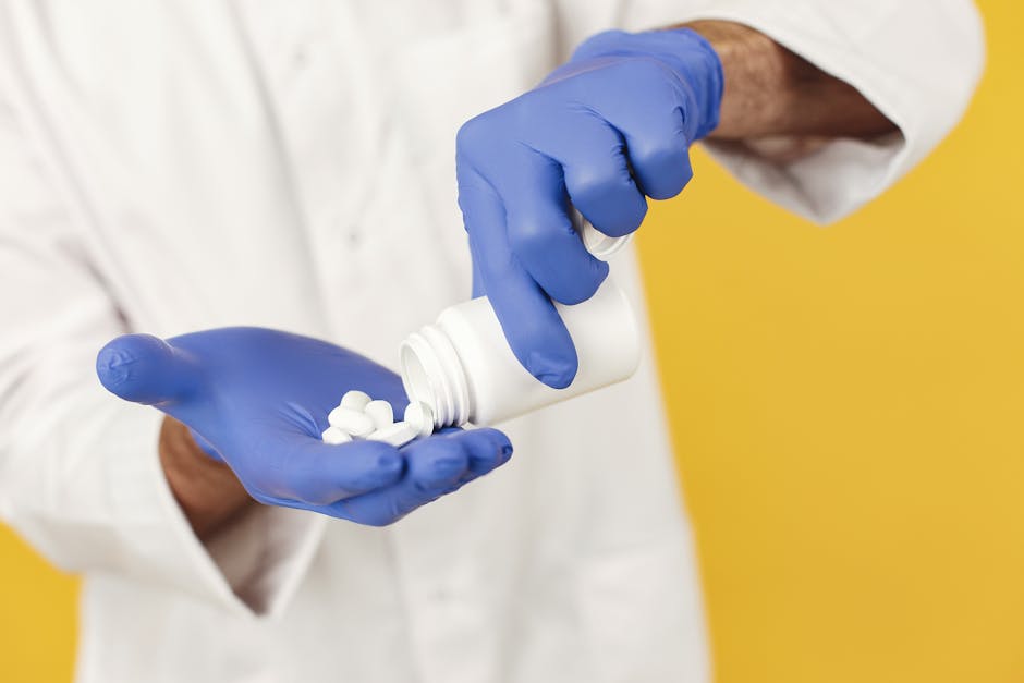 close up of a healthcare worker in gloves pouring pills from