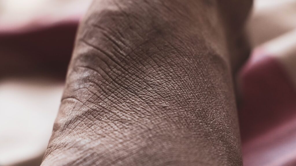 a close up of a person s foot with a pink blanket